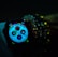 A smartwatch displays various health and activity metrics, including heart rate and activity rings, in a dimly lit environment. The screen is brightly lit with colorful graphics, providing a sharp contrast against the dark surroundings. The watch is worn on a wrist adorned with multiple beaded bracelets, adding a touch of personal style.